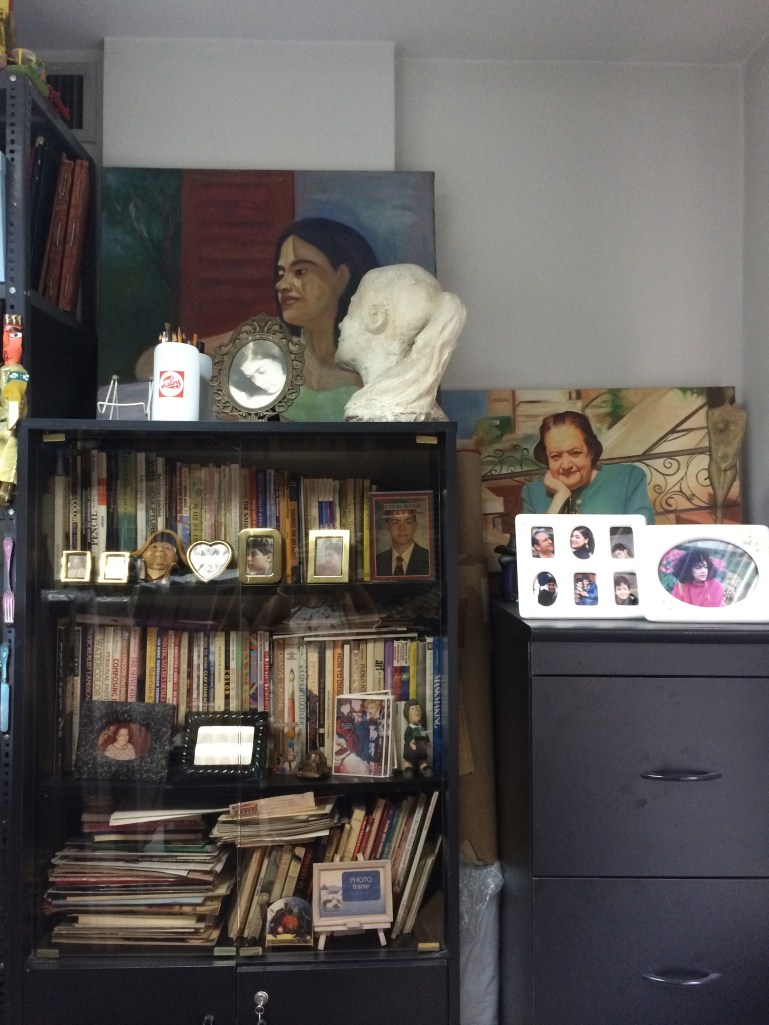 A photograph of Ginane's mother in the back and portrait of artist with valuable collection of art books